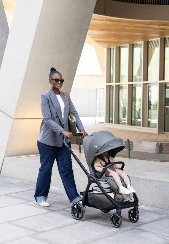 Une maman pousse sa poussette Joie, assise réversible face au monde